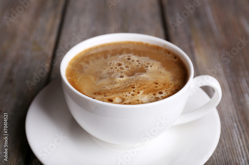 Cup of coffee with milk on wooden background