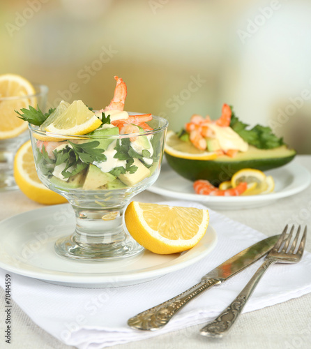 Tasty salads with shrimps and avocado in glass bowl and