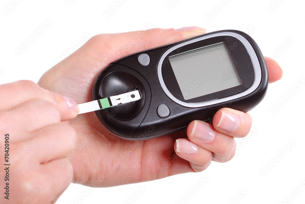 Closeup of strip for glucose testing and glucose meter Closeup of strip for glucose testing and glucose meter