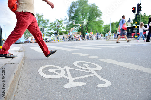 Photography Man in red trousers crossing street with traffic