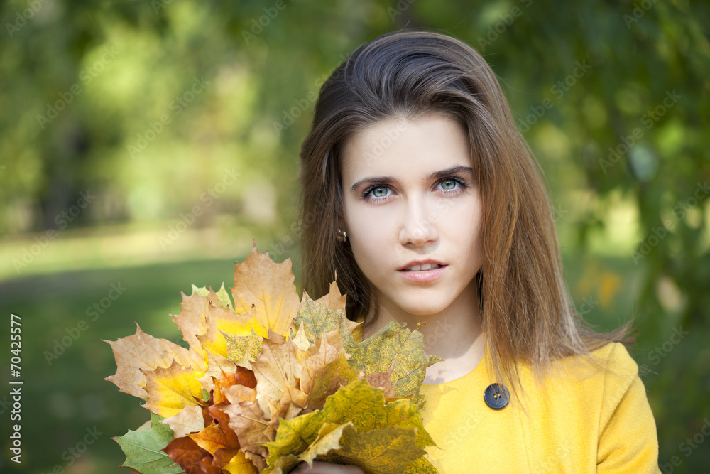 Happy young woman in yellow coat in autumn park Happy young woman in yellow coat in autumn park