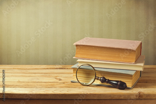 Old books with vintage magnifying glass