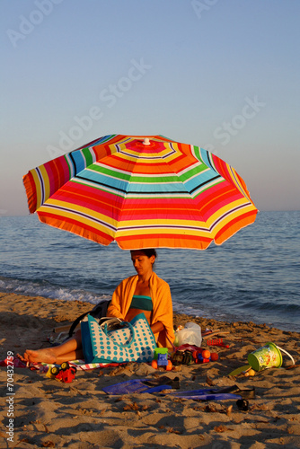 DONNA IN SPIAGGIA DOTTO L'OMBRELLONE photo