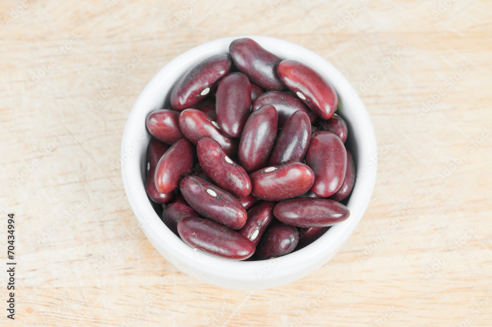 Kidney bean in white ceramic bowl on wood background. Kidney bean in white ceramic bowl on wood background.