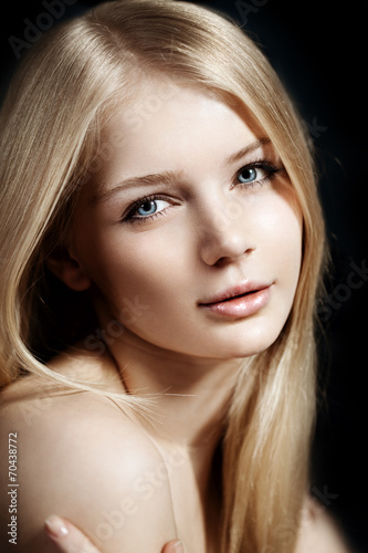 Woman face close up. A pretty young blond trendy. Girl with a be