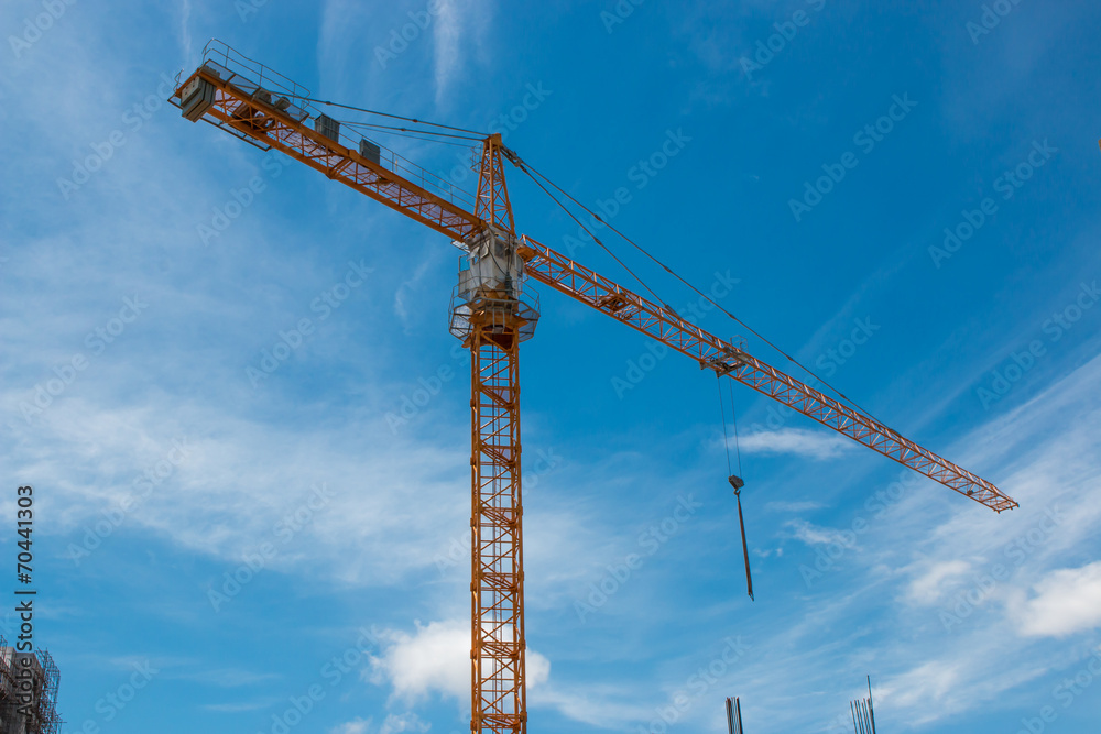 building and crane under construction against blue sky