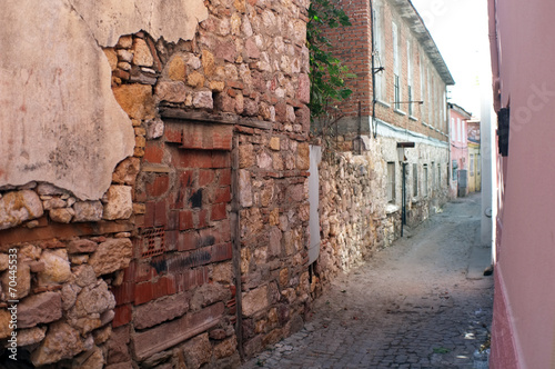 Narrow road between old damaged stone houses