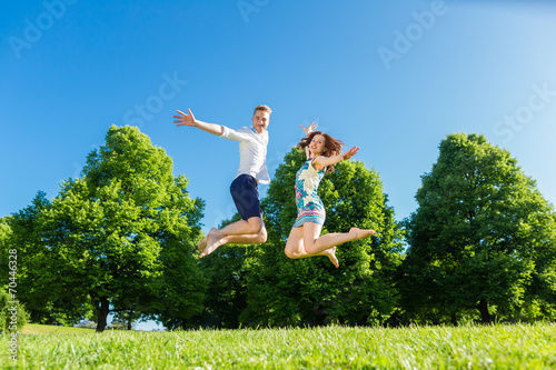 Paar springt verliebt auf Park Wiese