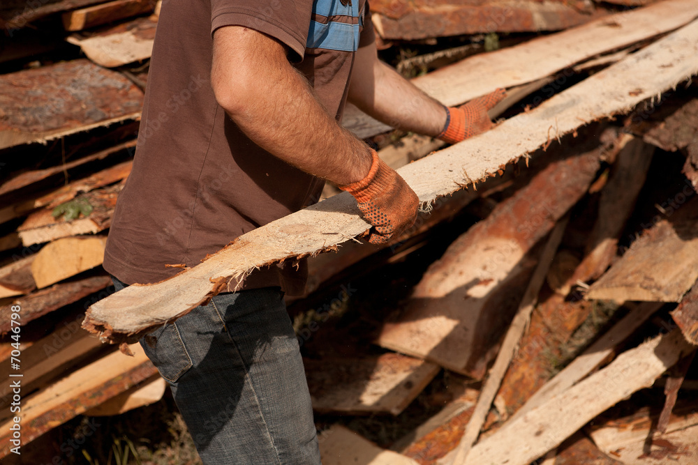 carpenter carrying a large wood plank on his hands carpenter carrying a large wood plank on his hands