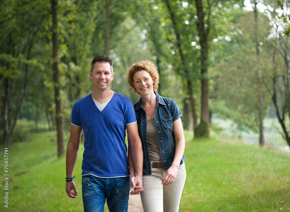 Cheerful couple walking together in the woods Cheerful couple walking together in the woods