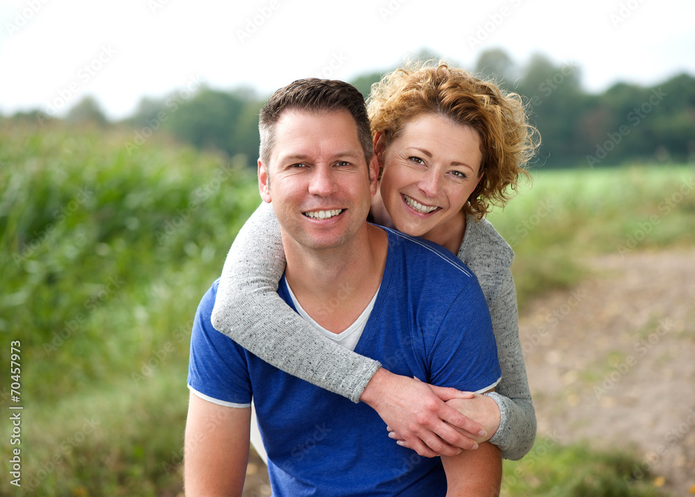 Smiling woman hugging her boyfriend outdoors Smiling woman hugging her boyfriend outdoors