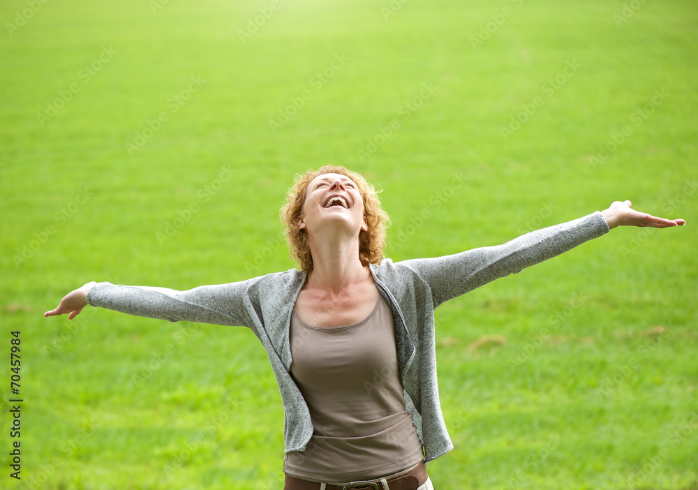 Carefree older woman smiling with arms open