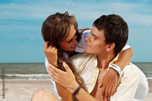 happy couple sitting on the beach © Artem Merzlenko
