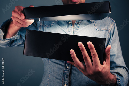 Young man opening an exciting box