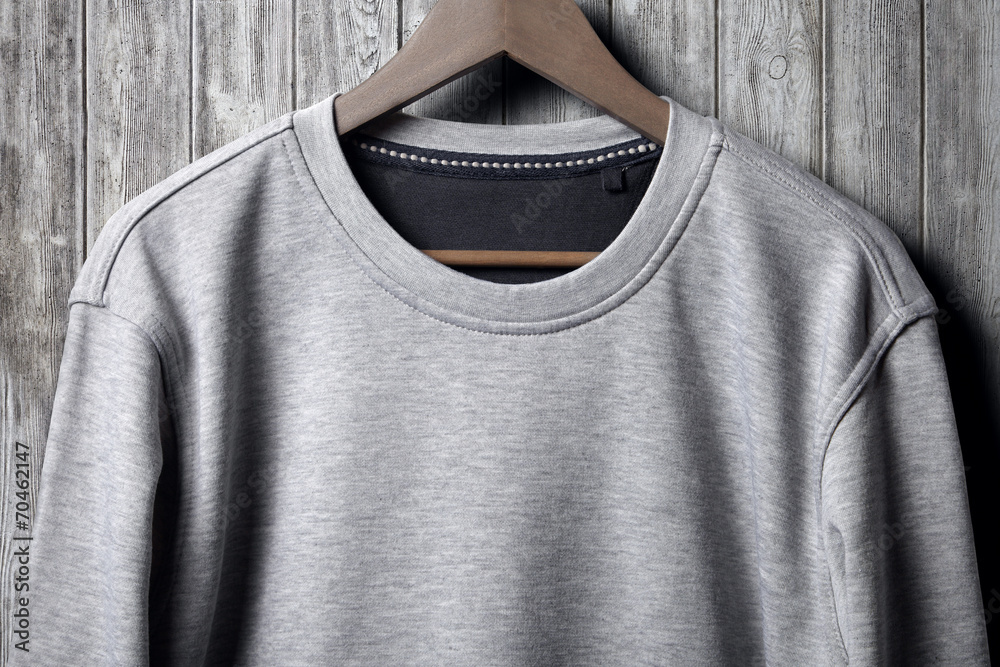 Grey jumper hanging on wood wall