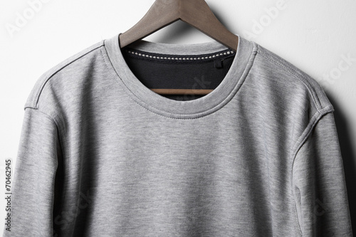 Grey jumper hanging on white wall