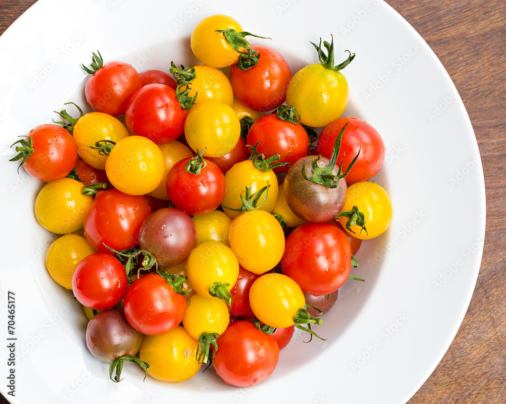 Colorful cherry tomatoes in white bowl