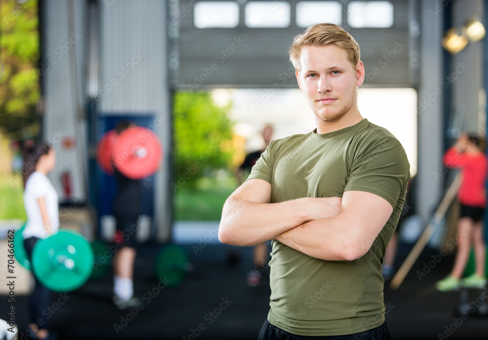 Male Athlete Standing Arms Crossed At Gym Male Athlete Standing Arms Crossed At Gym