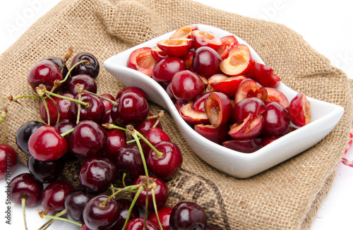 Cup of tasty pitted cherries and whole cherries