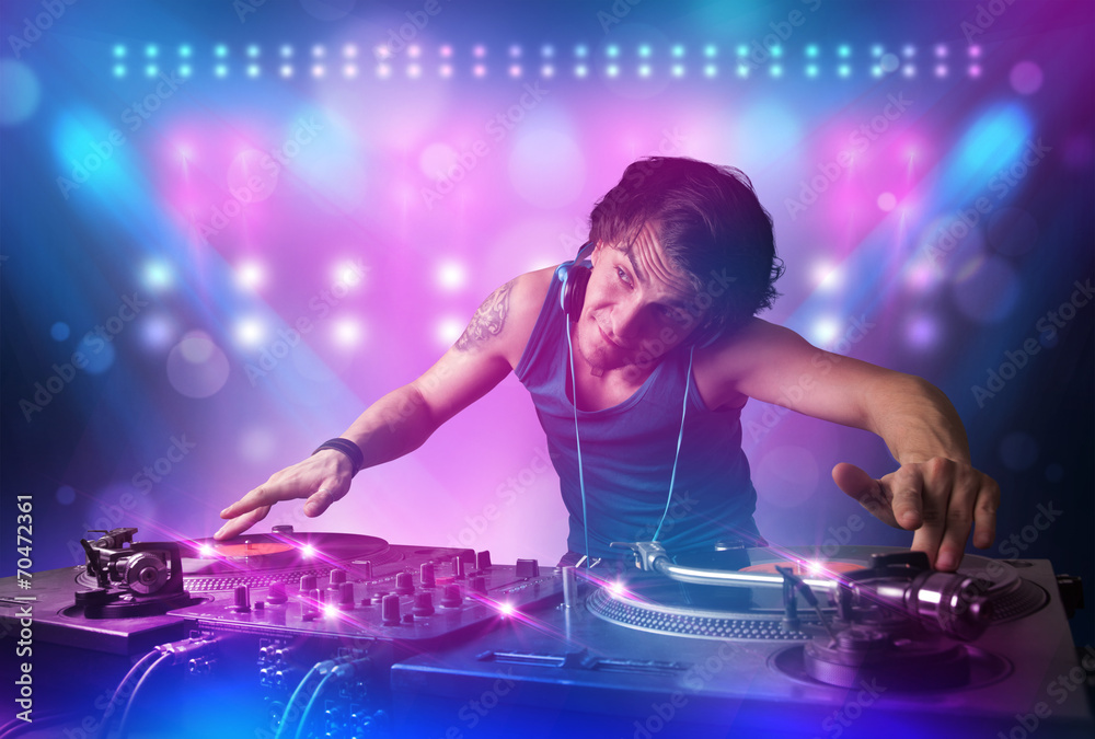 Disc jockey mixing music on turntables on stage with lights and - obrazy, fototapety, plakaty 