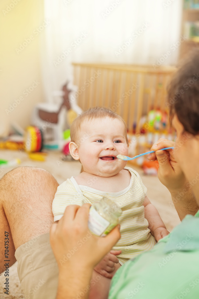 father feeding his cheerful baby father feeding his cheerful baby