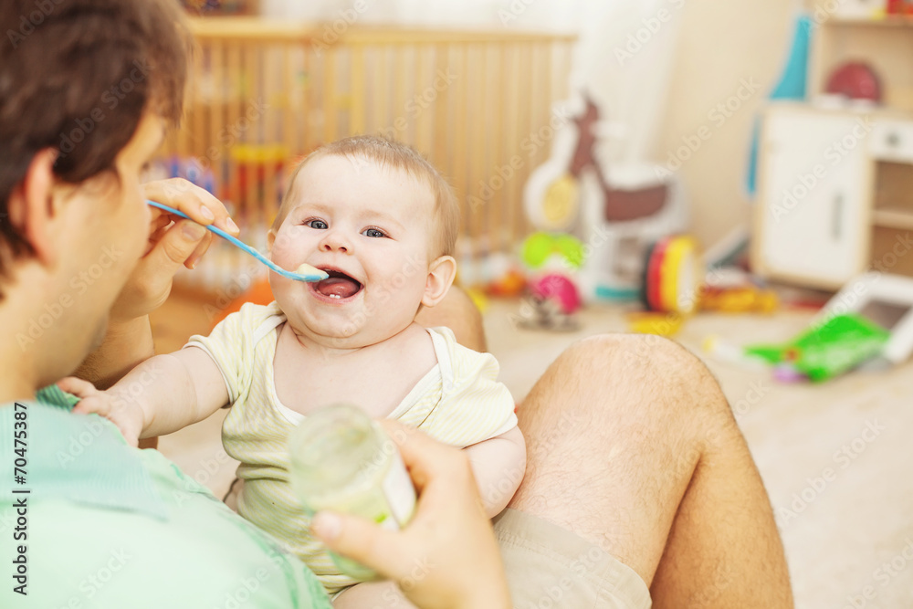 father feeding his cheerful baby father feeding his cheerful baby