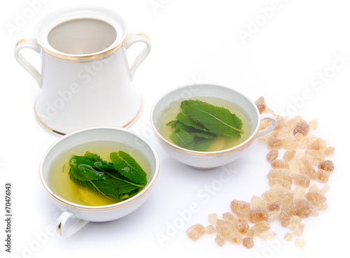 Composition with two cups of mint tea and brown cane sugar