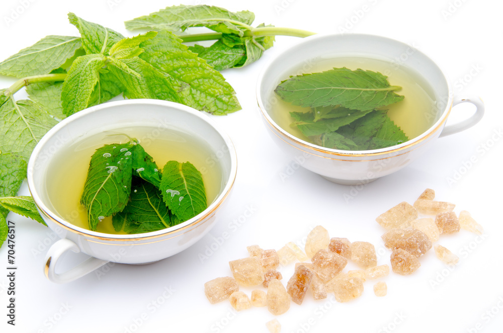 Composition with two cups of mint tea, fresh mint and brown cane Composition with two cups of mint tea, fresh mint and brown cane