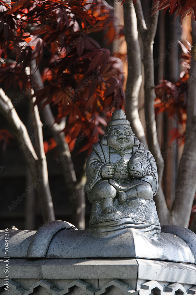 Fototapeta premium Japanese figurine with a fish on a fence in the province