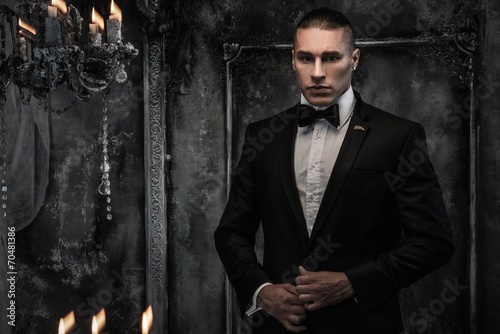 Photo Young man wearing tuxedo in classical interior