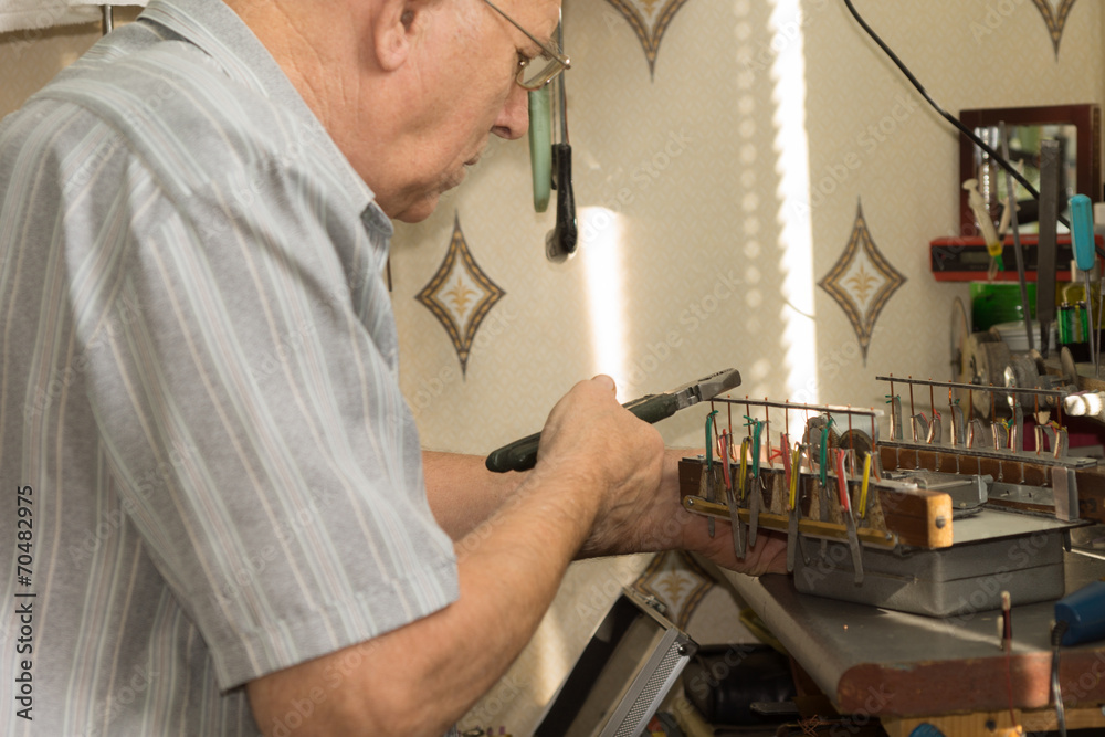 Old Man Working Electronic Device Using Pliers