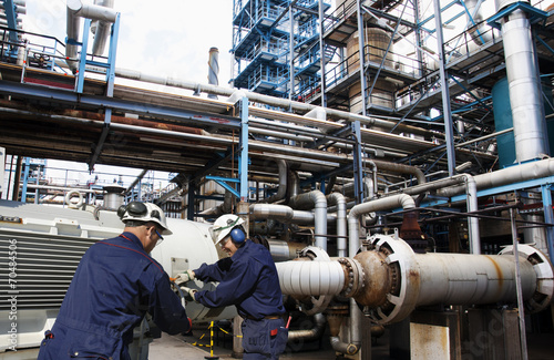 oil workers with main fuel-pumps inside refinery industry
