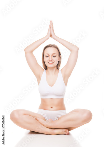 Young woman sitting in lotus position isolated © julenochek