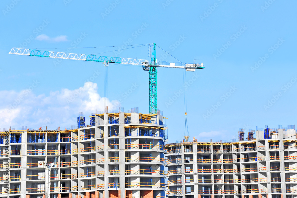 Crane and building construction site against blue sky Crane and building construction site against blue sky