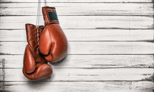 Boxing gloves hanging on wooden wall