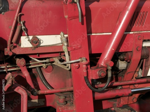 Detailaufnahme der Mechanik und Technik eines alten roten Traktor im Sommer bei Sonnenschein auf einem Straßenfest in Leopoldshöhe bei Bielefeld in Ostwestfalen-Lippe photo