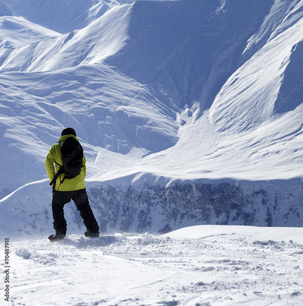 Snowboarder on top of off-piste slope at windy day