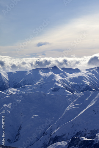 Snowy mountains and sunlight clouds at evening