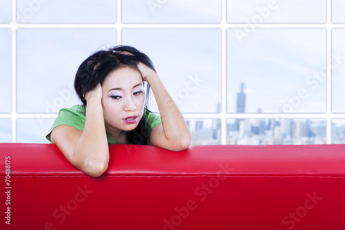 Close-up depressed female on red sofa indoor