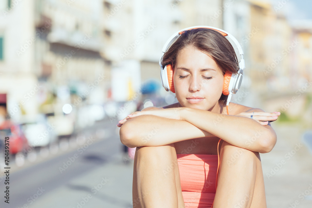 Beautiful Girl with Headphones Listening Music in the City