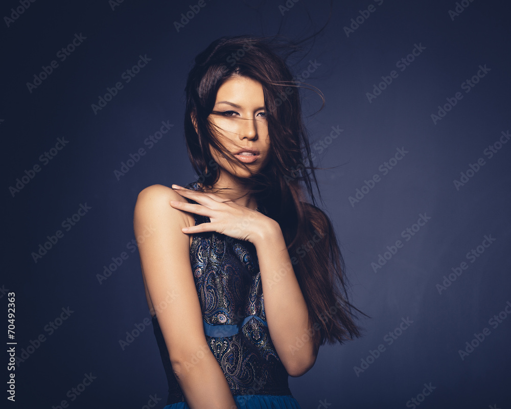 Naklejka premium Attractive girl with flying hair posing in studio