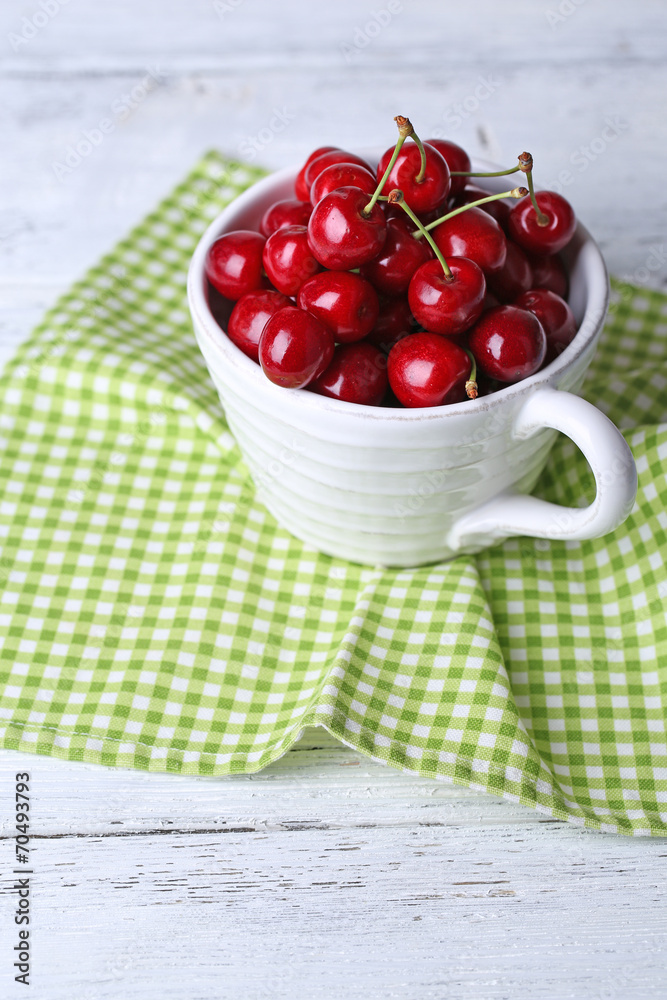 Sweet cherries in mug on wooden background Sweet cherries in mug on wooden background