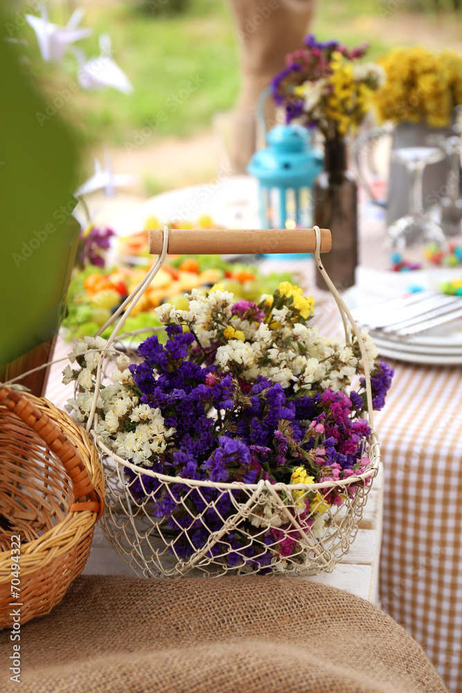 Basket with flowers on table, outdoors