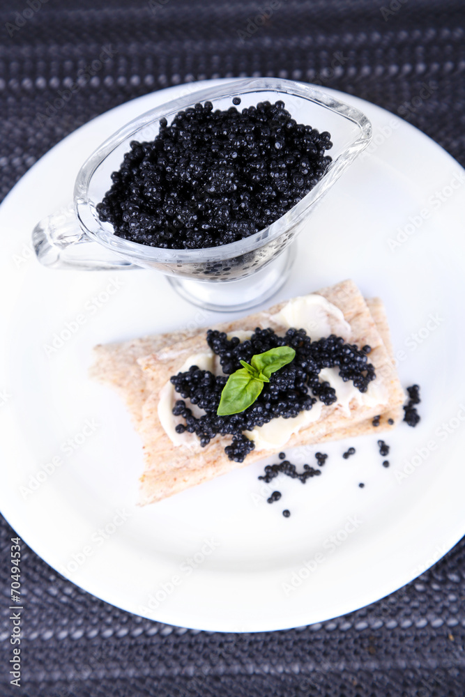 Slice of bread with butter and sauceboat with caviar Slice of bread with butter and sauceboat with caviar