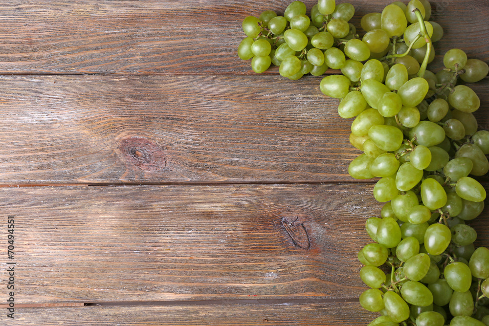 Bunch of ripe grapes on brown wooden background Bunch of ripe grapes on brown wooden background