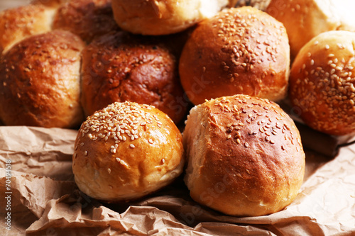 Tasty buns with sesame on rustic wooden background