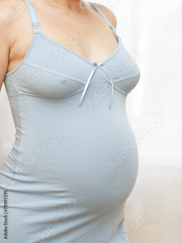 Pregnant woman in blue nightdress photo
