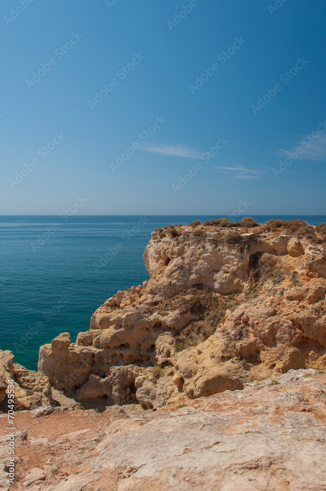 Algarve coast, Portugal. Rocks in the shoreline and blue water Algarve coast, Portugal. Rocks in the shoreline and blue water