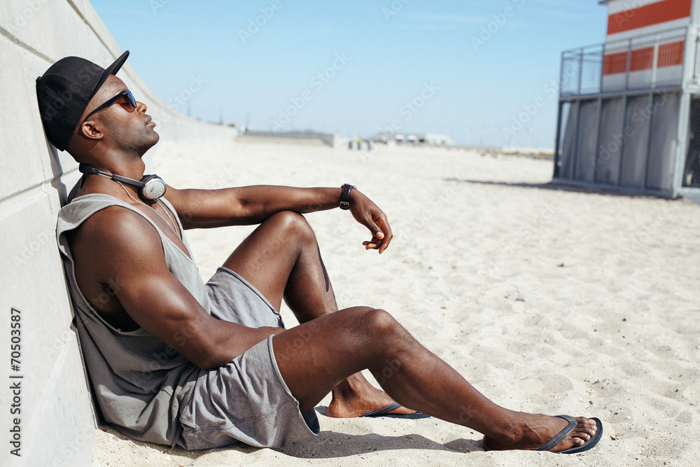 Man sitting on beach relaxing - obrazy, fototapety, plakaty 