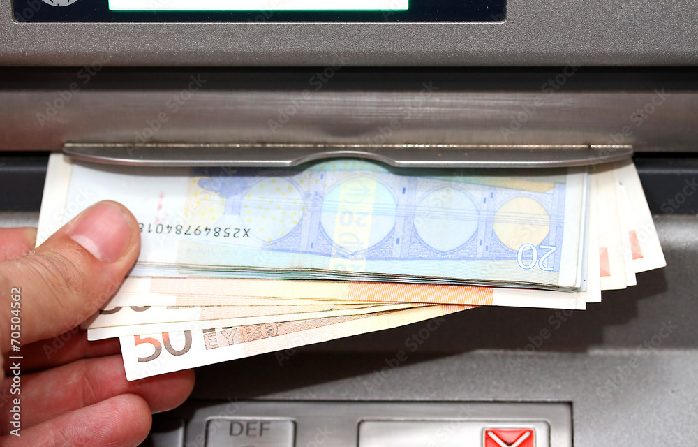 man takes money in EURO banknotes from an ATM man takes money in EURO banknotes from an ATM